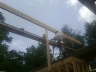 Carpenter setting a ridge beam over a new addition frame — Ice Dam Removal by Roofing Brothers in Walhalla