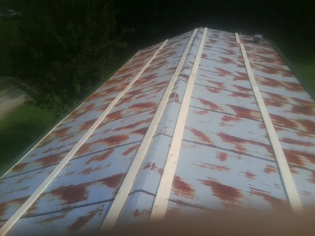 Rusted metal roof panels with new wood purlins before replacement — Storm Damage Roof Repair in Walhalla by Roofing Brothers