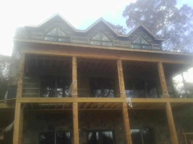 Dormers and porch framing on a large log home under construction — Roof Coating work by our crew in Walhalla