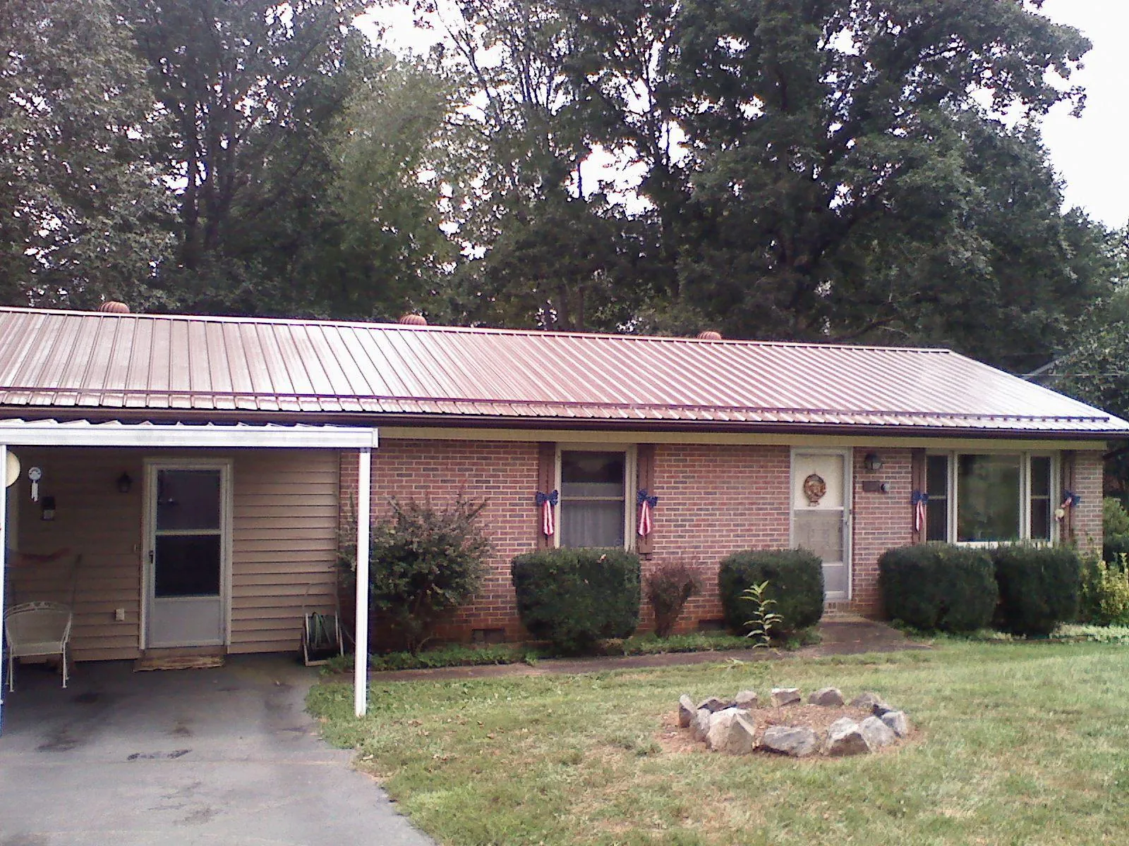 Bronze metal roof and carport on a brick ranch home — Roof Repair work by our crew in Walhalla
